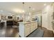 Open kitchen with island, granite countertops, and views of the living and dining areas at 5515 Cheatam Ave, Cumming, GA 30040
