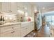 Modern kitchen with white cabinets, stone backsplash, stainless steel refrigerator, and farmhouse sink at 5515 Cheatam Ave, Cumming, GA 30040