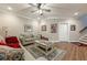 Inviting living room with ceiling fan, hardwood floors, gray sofa, and decorated walls at 5515 Cheatam Ave, Cumming, GA 30040