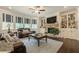 Spacious living room with a fireplace, built-in shelving, hardwood floors, and lots of windows at 5515 Cheatam Ave, Cumming, GA 30040