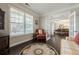 Cozy living room with hardwood floors, a window with blinds, and a view into the dining room at 5515 Cheatam Ave, Cumming, GA 30040