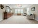 Spacious bedroom with a large dresser, mirror, and sitting area with lots of natural light from large windows at 5515 Cheatam Ave, Cumming, GA 30040
