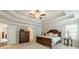 Large primary bedroom with a tray ceiling, plush carpet, and windows that provide an outside view at 5515 Cheatam Ave, Cumming, GA 30040