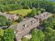 An aerial view showcases the community's brick townhomes surrounded by lush greenery and landscaping at 1950 Buford Dam Rd # 205, Cumming, GA 30041