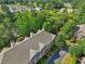Aerial shot of townhomes nestled amongst green trees with a pond and residential homes in the background at 1950 Buford Dam Rd # 205, Cumming, GA 30041