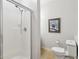 Bright bathroom featuring a walk-in shower with white enclosure, toilet, and wall art at 1950 Buford Dam Rd # 205, Cumming, GA 30041