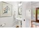 Elegant half bathroom with pedestal sink, modern fixtures, and decorative artwork at 1950 Buford Dam Rd # 205, Cumming, GA 30041
