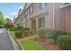 A row of charming brick townhomes with manicured front lawns and covered entries at 1950 Buford Dam Rd # 205, Cumming, GA 30041