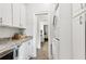Galley kitchenette with white cabinets, granite counters, and stainless appliances leading to laundry and a bedroom at 1950 Buford Dam Rd # 205, Cumming, GA 30041
