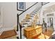 A staircase with wooden steps and white railing, with a view into the kitchen, and hardwood flooring at 1950 Buford Dam Rd # 205, Cumming, GA 30041