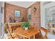 Inviting sunroom with a wooden table set, complemented by exposed brick and view of the outdoors at 1950 Buford Dam Rd # 205, Cumming, GA 30041