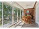 Bright sunroom features wood table, brick accent wall, and large windows with views of lush greenery at 1950 Buford Dam Rd # 205, Cumming, GA 30041