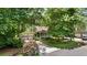View of a cozy two-story home with an attached two-car garage, surrounded by lush trees at 3627 Spring Meadow Court, Acworth, GA 30101