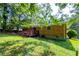 Brick home's backyard featuring a wooden deck, lawn, and mature trees, offering a private outdoor space at 379 Utoy Sw Cir, Atlanta, GA 30331