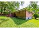 Brick home's backyard featuring a lawn and mature trees, offering a private outdoor space at 379 Utoy Sw Cir, Atlanta, GA 30331