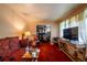 Cozy living room featuring vintage furniture, including a patterned sofa and ornate console table, with an open doorway at 379 Utoy Sw Cir, Atlanta, GA 30331
