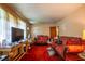 Cozy living room featuring patterned sofas and red carpeting in a quaint, older home at 379 Utoy Sw Cir, Atlanta, GA 30331