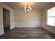 Formal dining room with wood floors, decorative molding, and modern chandelier at 7753 Hansel Ln, Lithonia, GA 30058