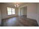 Bright dining room featuring stylish chandelier, wood-look floors, and classic wainscoting details at 7753 Hansel Ln, Lithonia, GA 30058