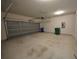 Spacious garage with garage door, concrete floor and trash cans at 7753 Hansel Ln, Lithonia, GA 30058