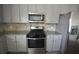 Updated kitchen with stainless steel appliances, granite countertops, and ample storage space at 7753 Hansel Ln, Lithonia, GA 30058