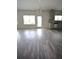 Well-lit living space with wood-look floors, offering access to outdoor area and adjacent kitchen at 7753 Hansel Ln, Lithonia, GA 30058
