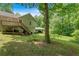 Backyard view of the house with a deck and carport amidst lush greenery at 144 Wiley Dr, Douglasville, GA 30134
