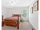 Bright bedroom features a wood frame bed, a ceiling fan, and a window at 144 Wiley Dr, Douglasville, GA 30134
