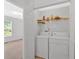Bright laundry room features washer, dryer, and shelving for storage at 144 Wiley Dr, Douglasville, GA 30134