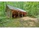 Well-maintained outbuilding with tractor and equipment amongst lush foliage at 144 Wiley Dr, Douglasville, GA 30134