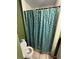 Bathroom featuring a leafy shower curtain, white tiled floors, and a white toilet at 1750 Beechwood Sw Blvd, Atlanta, GA 30311