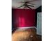 Bedroom with hardwood floors and an ornate ceiling fan, red walls and adjacent bathroom at 1750 Beechwood Sw Blvd, Atlanta, GA 30311