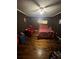 A bedroom featuring a floral comforter, a wood bedframe, and a red loveseat at 1750 Beechwood Sw Blvd, Atlanta, GA 30311