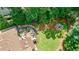 Aerial view of a beautiful home, deck and backyard featuring lush landscaping, mature trees and a charming firepit seating area at 4115 Falls Ridge Dr, Johns Creek, GA 30022