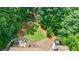 Aerial view of backyard featuring mature trees, lush landscaping, and a charming fire pit area with seating at 4115 Falls Ridge Dr, Johns Creek, GA 30022