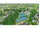 Aerial view showcases the community's tennis courts, pools, and luxurious homes surrounded by dense trees at 4115 Falls Ridge Dr, Johns Creek, GA 30022