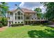 Expansive backyard with lush green grass, mature trees, stone stairs and a spacious deck for outdoor entertaining at 4115 Falls Ridge Dr, Johns Creek, GA 30022
