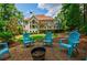 Lush backyard with a house view, offering a deck, patio and outdoor seating around a fire pit at 4115 Falls Ridge Dr, Johns Creek, GA 30022
