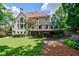 Expansive backyard with lush green grass, mature trees, stone stairs and a spacious deck for outdoor entertaining at 4115 Falls Ridge Dr, Johns Creek, GA 30022