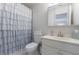 Clean bathroom with white vanity, toilet, and a decorative shower curtain at 4115 Falls Ridge Dr, Johns Creek, GA 30022