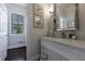 Bathroom with a vanity, mirror and artwork; doorway showing view to the backyard at 4115 Falls Ridge Dr, Johns Creek, GA 30022