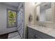 Bathroom vanity with marble countertop, single sink, large framed mirror, and shower with curtain by a window at 4115 Falls Ridge Dr, Johns Creek, GA 30022