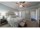 Well-lit bedroom with a ceiling fan, plush bedding, and a stylish mirrored nightstand at 4115 Falls Ridge Dr, Johns Creek, GA 30022
