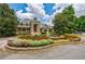 Community clubhouse with beautiful landscaping, flowering plants, a fountain and lush green trees at 4115 Falls Ridge Dr, Johns Creek, GA 30022