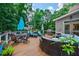 Stunning outdoor deck with various seating options, a grill, and tranquil views of the surrounding greenery at 4115 Falls Ridge Dr, Johns Creek, GA 30022