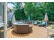 Spacious deck with stylish outdoor seating, umbrellas, and a peaceful view of the wooded backyard at 4115 Falls Ridge Dr, Johns Creek, GA 30022