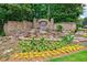Elegant community entrance waterfall and landscaping with stone walls and beautiful flowers at 4115 Falls Ridge Dr, Johns Creek, GA 30022
