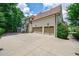 Exterior view of a home featuring a three-car garage, and a well-maintained driveway at 4115 Falls Ridge Dr, Johns Creek, GA 30022