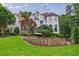 Charming exterior view featuring a lush lawn, manicured landscaping, and stone retaining wall at 4115 Falls Ridge Dr, Johns Creek, GA 30022
