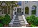 Inviting front entrance with stone steps, arched windows, and manicured shrubs at 4115 Falls Ridge Dr, Johns Creek, GA 30022